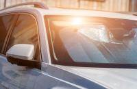 Car sitting in heat with sun reflecting off sun shade