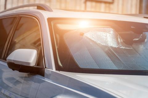 Car sitting in heat with sun reflecting off sun shade
